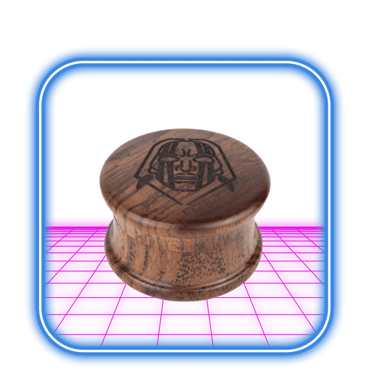 En graverad 2-delad träkvarn av Indian Spirit sitter på en reflekterande rosa yta, inramad av en blå fyrkant. I närheten föreslår ett 510-batteri modern anslutning och innovativ potential för klassiska produkter som denna.